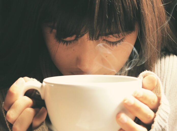 woman holding white cup