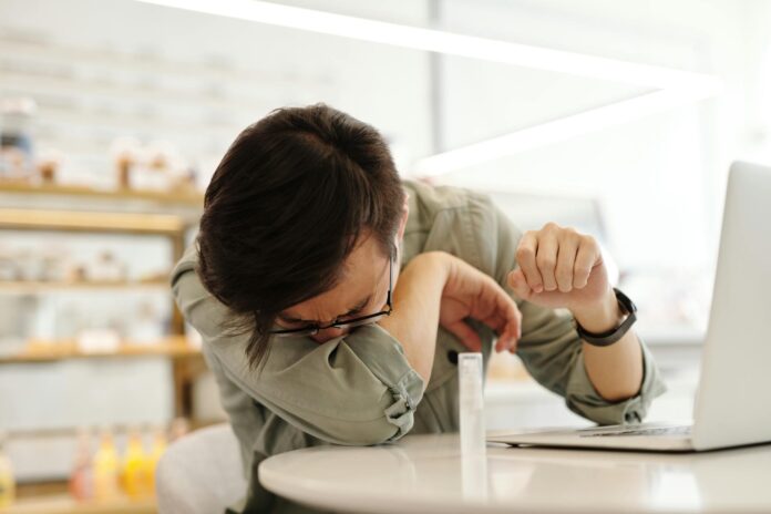 a sick man covering his mouth